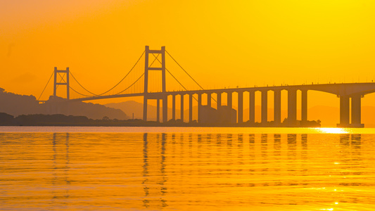 8K唯美海平面跨海大桥倒影金色光芒映照海面延时视频