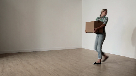 一对夫妇带着纸板箱穿过空荡荡的房间视频