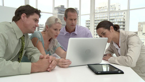 四个商人在办公室会议中使用笔记本电脑讨论事情26秒视频