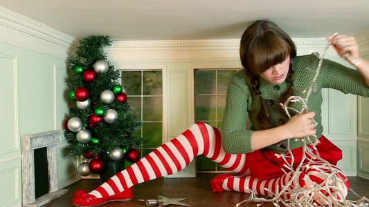 大人国小人国的超现实主义概念视频年轻女人在小房间里装饰圣诞树时感到沮丧视频