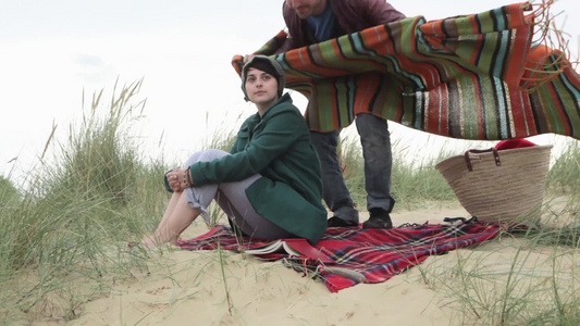 年轻人在沙丘上用毯子把女朋友包起来视频