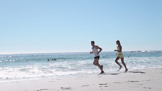 在海滩上慢跑的年轻夫妇视频