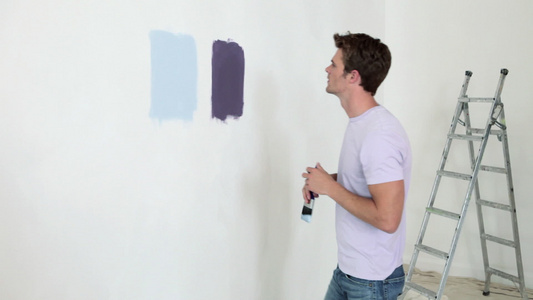 一对夫妇在墙上看不同的油漆视频
