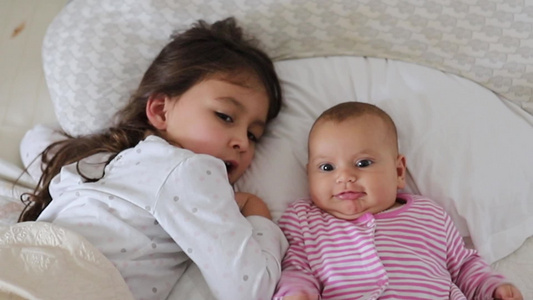 小女孩和她快乐的妹妹睡在床上视频