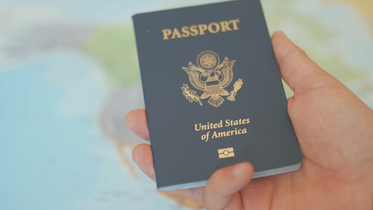 手拿着美国护照背后是北美地图视频