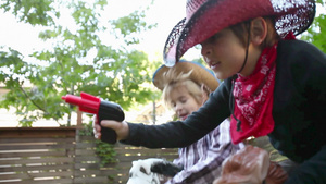 两个男孩打扮成牛仔拿着玩具枪摇着摇马19秒视频