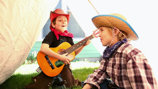 两个男孩打扮成牛仔唱歌弹吉他视频