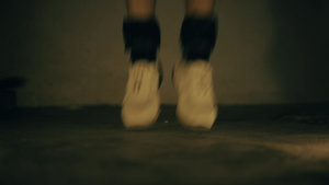 穿着白色运动鞋和黑色脚踝重量的双腿紧合镜头14秒视频
