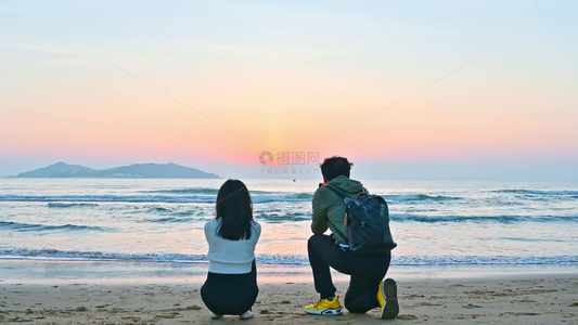 海南三亚海棠湾海边沙滩日出朝霞情侣相互依靠甜蜜的蹲守日出视频