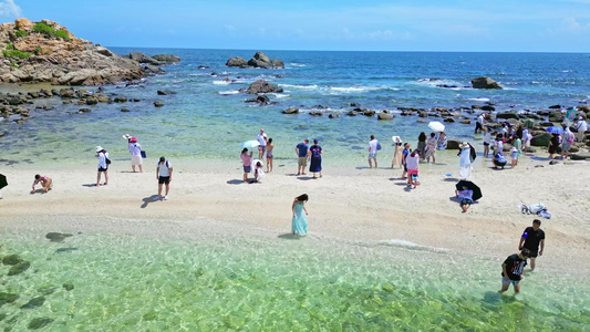 高视角航拍俯视海南三亚海棠湾蜈支洲岛玻璃海白沙滩上旅游度假的游客及沙滩躺椅视频