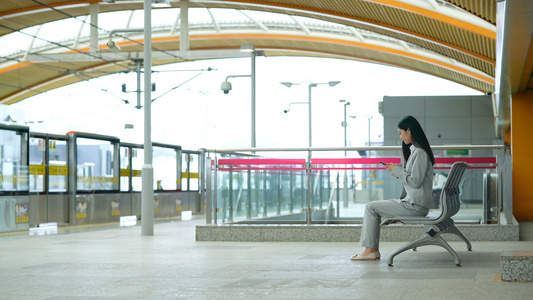4k地铁站坐在座椅上等待地铁的女生视频