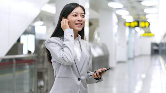4k商务女性在地铁站接电话打电话视频