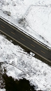 俯拍雪中的公路雪景航拍视频公路运输视频