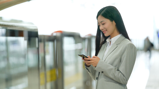 4k在地铁站内使用手机等待地铁的女性白领视频