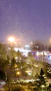实拍北方城市风雪交加的夜晚街道上缓慢的车流行人2组镜头视频