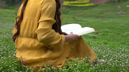 4K少女坐在草坪上看书阅读翻书实拍视频视频