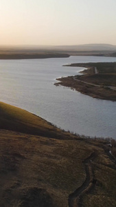 航拍夕阳下逆光的湖面和连绵起伏的山包内蒙古视频