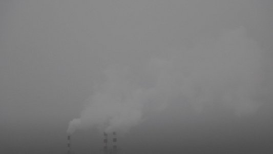 烟雾从锅炉房的烟囱里冒出来在灰雾的冬天视频