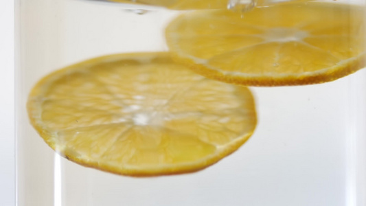 透明玻璃中的苏打水和克莱门汀片清洁新鲜有机水果以实现视频