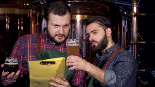 两个男性酿酒者检查他们一起制造的美味手工艺啤酒视频