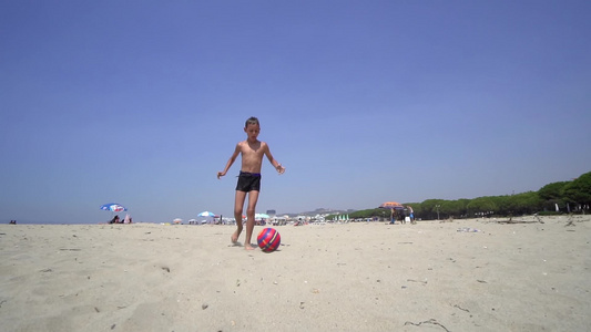 暑假期间在海滩上踢足球的男孩积极体育概念视频
