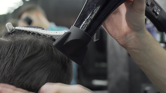 使用吹风机和客户发型的理发师用光干衣视频