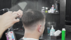 一位男性客户的专业理发师润湿和梳理头发11秒视频