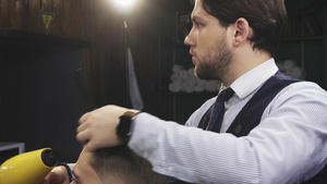 专业理发师吹干客户的头发8秒视频