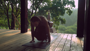 一个男人在木制平台上练习瑜伽16秒视频