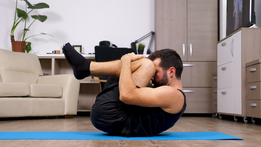 坐在起居室地板上的年轻健身男做不同的瑜伽姿势视频