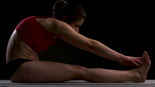 女孩练习瑜伽伸展手臂和腿手抚摸脚视频