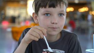 男孩在咖啡厅里吃巧克力蛋糕和冰淇淋25秒视频