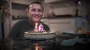 快乐的男子庆祝他46岁生日在室内自制烤蛋糕上吹蜡烛10秒视频