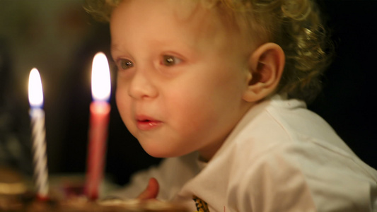 小男孩在生日蛋糕上吹了两根蜡烛视频