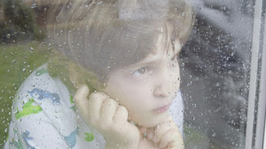 男孩在雨天从窗户向外看26秒视频