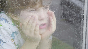 男孩在雨天从窗户向外看26秒视频