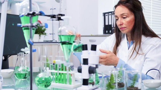 在生物化学研究中心女科学家正在查看植物测试样品视频