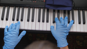 电子钢琴手指按着钢琴钥匙手握橡胶手套25秒视频