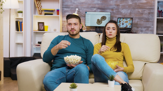 年轻夫妇在沙发上放松观光电视视频