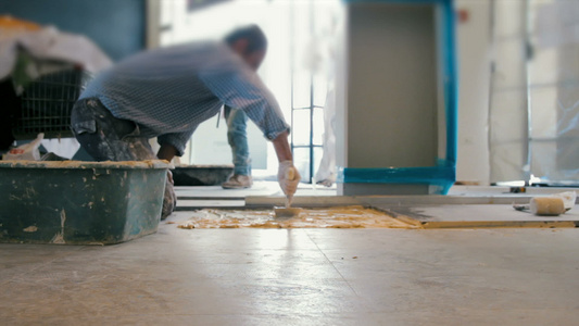 将阴铁主义瓷砖放在地板上的工人电影视频