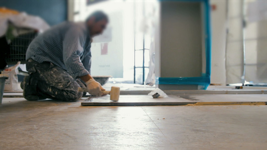 将阴铁主义瓷砖放在地板上的工人电影视频