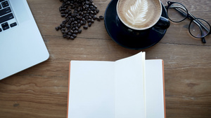 木制桌上的空白白书风纸翻页带笔记本的工作空间书籍咖啡杯10秒视频