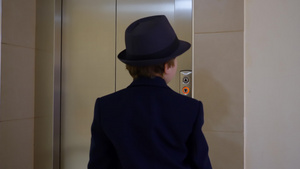 穿着西装帽子和公文包的小男孩进入电梯12秒视频