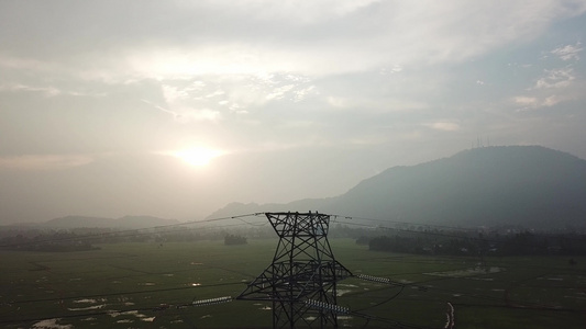 在稻田用背景山丘观察空中电塔水稻田视频