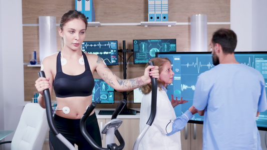 体育科学女医生在电视监视器上检查女运动员的能量视频
