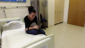 有吸引力的少女在医院里发送短信坐在床上在手机上输入14秒视频