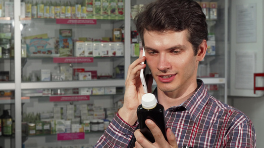 青年男子在药店购物时使用智能电话视频