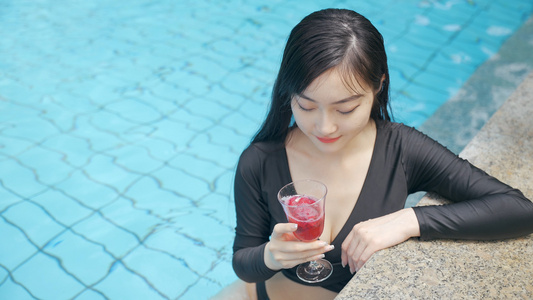 4k年轻女性泳池水里浸泡冰镇饮料视频