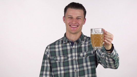 英俊的年轻男子笑得开心快乐把啤酒拿在相机上视频