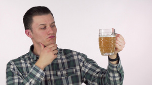年轻男人摸着下巴检查啤酒9秒视频